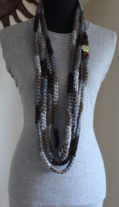 a woman wearing a gray shirt and multi - stranded beaded necklace on top of a mannequin