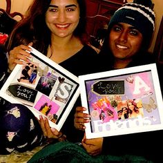 two women holding up pictures with writing on them