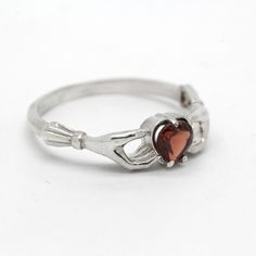 Claddagh Heart Genuine Garnet Sterling Silver Engagement Ring◆ The Claddagh ring has centuries of history, but today it symbolizes three things: friendship, loyalty and love. A beautiful small women ring with black heart zircon on the top. Two skeleton hands hold the black heart from different sides. Perfect fit for engagement or wedding in gothic style occasion. Simple design make it very comfortable and convenient for wearing everyday. We did blacked oxidation on the top and black zircons inse Gothic Rings For Valentine's Day Gift, Valentine's Day Gothic Rings As Gift, Gothic Sterling Silver Promise Jewelry, Adjustable Gothic Style Rings For Anniversary, Gothic Heart-shaped Anniversary Jewelry, Classic Heart Ring With Birthstone For Gift, Classic Birthstone Heart Ring Gift, Classic Heart-shaped Birthstone Ring Gift, Symbolic Heart Shaped Rings As Gifts