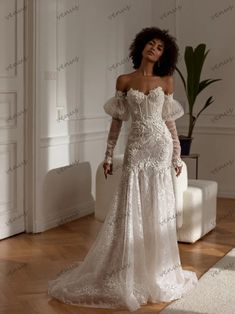 a woman in a white wedding dress standing on a wooden floor with her arms behind her back