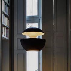 a lamp that is sitting in the middle of a room next to a book shelf