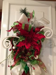 a door decorated with red and green ribbons, white candy canes and christmas decorations