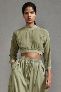 Green three fourth sleeves crop top in textured cotton with ribbed waistline, neckline and sleeve hem. Paired with a baggy-fit cargo pants with strap details on pockets. - Aza Fashions Relaxed Fit Cropped Tops With Elastic Waistband, Cropped Relaxed Fit Tops With Elastic Waistband, Cotton Crop Top With Elastic Waistband, Cropped Cotton Tops With Elastic Waistband, High Neck Crop Top, Pant For Women, Baggy Cargo Pants, Green Pants, Neck Crop Top