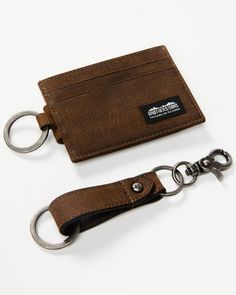 a brown leather card case and keychain on a white background