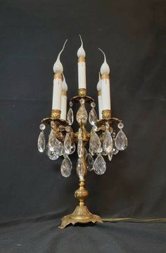 an antique brass and crystal candelabra with four candles on it's base