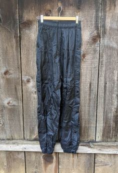 Classic nylon tearaway pants, 1990s vintage. Cool Y2K swishy pants, with snap up sides for easy on/off and unexpected tearaways...;) Lightweight and waterproof, perfect athletic or hiking gear, or everyday streetwear. Brand : Athletic Works 100% nylon Labeled size S All measurements taken with garment lying flat, double where necessary 12 inches across 'natural' waist, at rest (this can comfortably stretch up to another 2 inches) hips loose, but roughly 21 inches across 13.5 inch rise 29 inch inseam 42 inch outseam 4.5 inches across ankle openings, at rest (this can easily stretch up to another 2 or so inches) Very good vintage condition. Have a question?  Get in touch!  Always happy to talk. 90s Style Nylon Sports Pants, 90s Style Black Sports Pants, Tearaway Pants, Everyday Streetwear, Swishy Pants, Pants Y2k, Waterproof Pants, Nylon Pants, Y2k Black