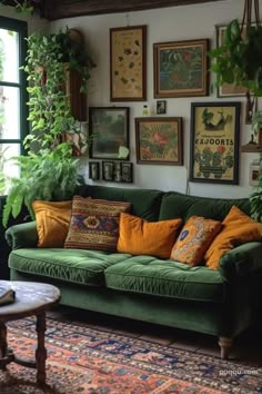 a living room filled with green couches and lots of pictures on the wall above them