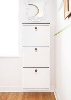 a white dresser sitting in the corner of a room