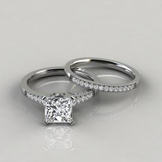 two engagement rings with diamond bands on each band and the center stone is set in white gold