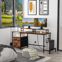 a computer desk sitting in front of a window with pictures on the wall above it