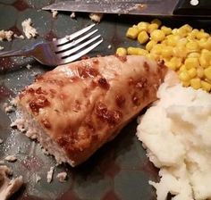 a plate with mashed potatoes, corn and meat on it next to a fork