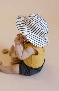 Keep your little sailor shaded with this adorably striped bucket hat featuring a broad brim and an adjustable chin strap. 100% organic cotton Machine wash, tumble dry Imported Summer Cotton Sun Hat For Playtime, Summer Cotton Bucket Hat For Playtime, Summer Cotton Hat For Play, Playful Cotton Hats With Upf 50+, White Bucket Hat For Playtime, Playful Cotton Hat With Upf 50+, Playful Cotton Hats With Uv Protection, Cotton Bucket Hat For Playtime, Adjustable Cotton Sun Hat For Playtime