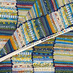 a close up of a patchwork quilt with a ruler in the foreground and several strips of fabric on it