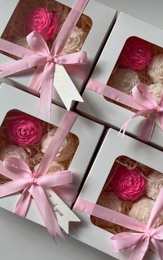 four pink and white cupcakes in a box