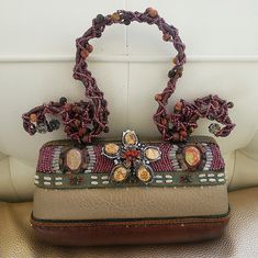 a purse with beaded decorations on it sitting on a table next to a wall