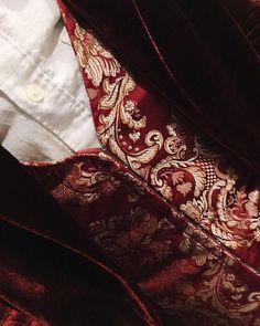 a close up view of a red and gold tie on a man's shirt