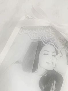 a black and white photo of a woman wearing a veil