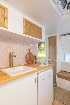 a kitchen area with sink, dishwasher and window in the backround