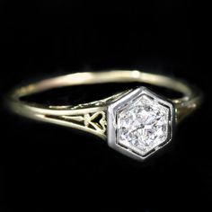 an antique diamond engagement ring on a black background