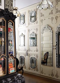 an antique looking display case in front of mirrors and other decorative wallpapered items