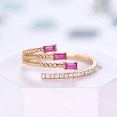 two gold rings with pink stones and diamonds