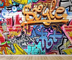 a wall covered in lots of graffiti next to a wooden floor