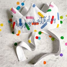 a birthday crown with confetti on it and the words happy birthday written on it