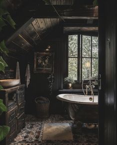 an old fashioned bathtub sits in the corner of a rustic bathroom with dark wood walls and flooring