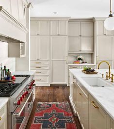 a kitchen with white cabinets and an area rug