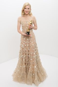 a woman in a dress holding an award