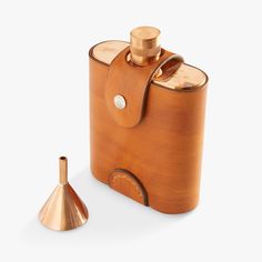 a wooden flask with a metal funnel on the side and a copper cup next to it