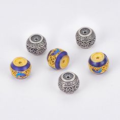 five beads with designs on them sitting next to each other, all in gold and blue