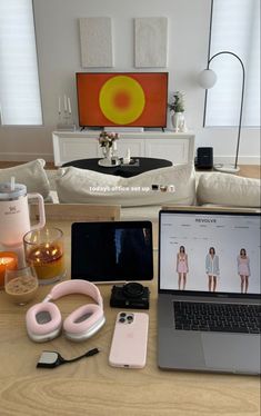 an open laptop computer sitting on top of a table next to headphones and other items