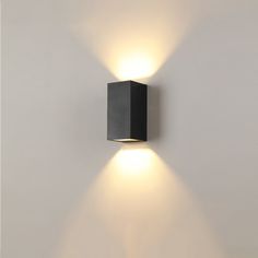 a wall light with two lights on the side of it in a white walled room