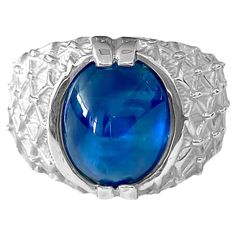 Introducing this captivating ring crafted from sterling silver, featuring a striking 6.00 carat cabochon-cut blue sapphire, securely set in prongs. With its deep blue hue and natural earth-mined origin, this sapphire adds a touch of elegance to any ensemble. Perfect for those who appreciate the beauty of genuine gemstones, it's a timeless addition to any jewelry collection. Blue sapphire helps make one detached, and protects against envy. It can be worn for good luck and for protection against evil spirits. Blue Sapphire gives its wearer mental clarity and clears confusion and doubts. Gorgeous silver and sapphire ring. Perfect unisex gemstone ring. Key Features: Metal: sterling silver. Center stone: 100% natural earth mined blue sapphire. 6.00cts. Cabochon cut set in prongs. Sapphire Cabochon Ring, Sapphire Cabochon, Blue Sapphire Ring, For Good Luck, Cabochon Ring, Ring Crafts, Blue Sapphire Rings, Natural Blue Sapphire, Natural Earth