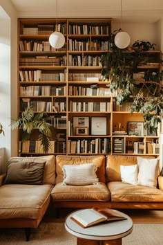 a living room filled with lots of furniture and bookshelves next to a window