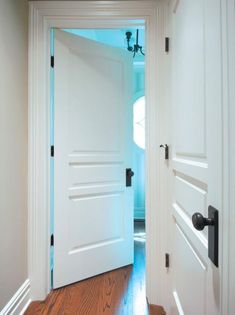 an open door leading to another room with wood floors and white walls, along with a hardwood floor