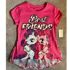 This Vibrant My Little Pony Girls Top Is A Must-Have For Any Young Mlp Fan! The Pink Hi Low Design Is Both Stylish And Comfortable, Perfect For Everyday Wear. Available In Multiple Sizes, This New Top Features The Beloved My Little Pony Character Family And Is Sure To Be A Hit With Kids And Parents Alike. Don't Miss Out On This Super Cute Addition To Your Little One's Wardrobe! My Little Pony Characters, Girls Top, New Top, Girl Top, The Pink, Kids And Parenting, My Little Pony, Kids Shirts, Pink White