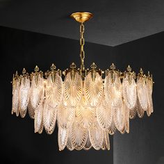 a chandelier hanging from the ceiling in a room with black walls and flooring