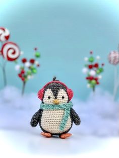 a penguin with a knitted hat and scarf standing in front of candy canes