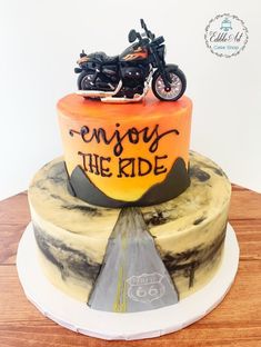 a motorcycle cake with the words enjoy the ride written on it and an orange background