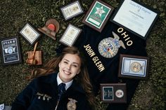 a woman laying on the ground surrounded by plaques and other items that include police badges