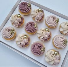 twelve cupcakes with pink frosting and gold decorations