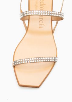 a women's sandal with crystal straps and an open toe, on a white background