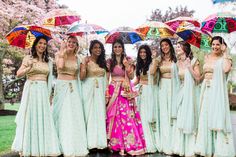 a group of women standing next to each other holding umbrellas