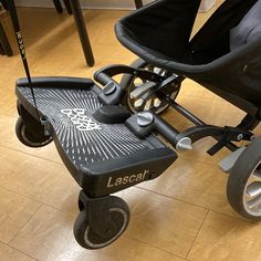 a black stroller with wheels on the floor