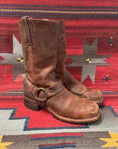 From Blackbird Vintage of Sedona, Arizona  This is a great pair of brown leather Vintage Frye Square toe harness Moto boots, Men's size 10.5,  circa 1990's.  They feature chunky long lasting Vibram lug soles! These great boots have a 1.75" heel and are 13" Tall.  They have a fantastic patina! They are in distressed and broken-in vintage condition. They are very well-made and have lots of life left! Condition Notes: -Worn, broken in, and distressed with scuffing, soiling, staining -Appears to be Rugged Boots With Bridle Leather And Leather Sole, Leather Moto Boots With Goodyear Welt For Western Events, Rugged Bridle Leather Boots With Leather Sole, Rustic Snip Toe Moto Boots For Outdoor, Oiled Leather Moto Boots With Snip Toe For Outdoor, Western Brown Bridle Leather Boots, Western Moto Boots With Leather Sole For Outdoor, Leather Moto Boots For Western-themed Events, Rustic Oiled Leather Boots For Outdoor