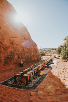 an outdoor seating area in the desert with sun shining on it's rocks and trees