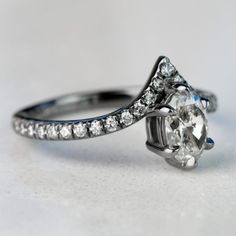 a close up view of a diamond ring on a white surface with diamonds around it