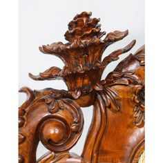 an ornate carved wooden headboard with flowers and leaves on the top, against a white background